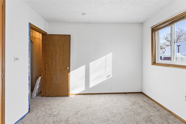 unfurnished room featuring carpet floors and a textured ceiling