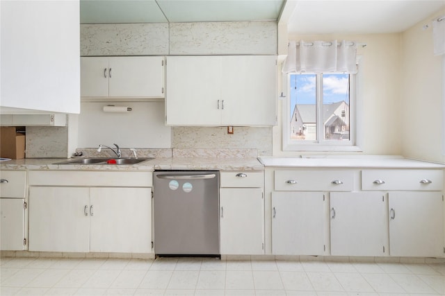 kitchen featuring a sink, decorative backsplash, light countertops, and dishwasher