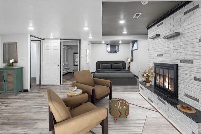 interior space with visible vents, a fireplace, light wood-style flooring, and recessed lighting