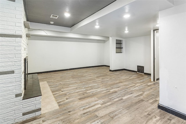 finished basement with recessed lighting, visible vents, a multi sided fireplace, wood finished floors, and baseboards