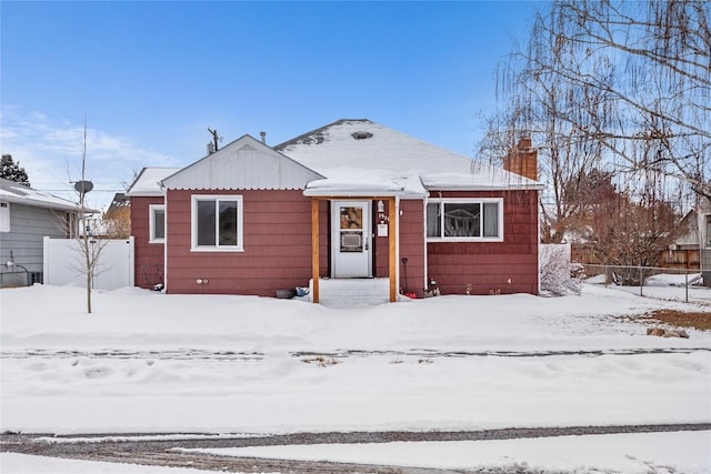 bungalow featuring a chimney and fence