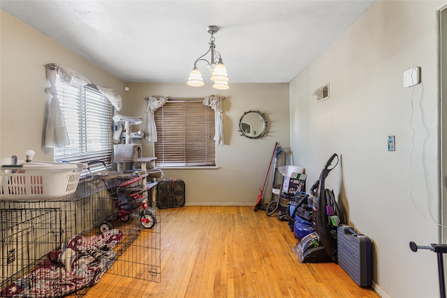 misc room with light hardwood / wood-style flooring and an inviting chandelier