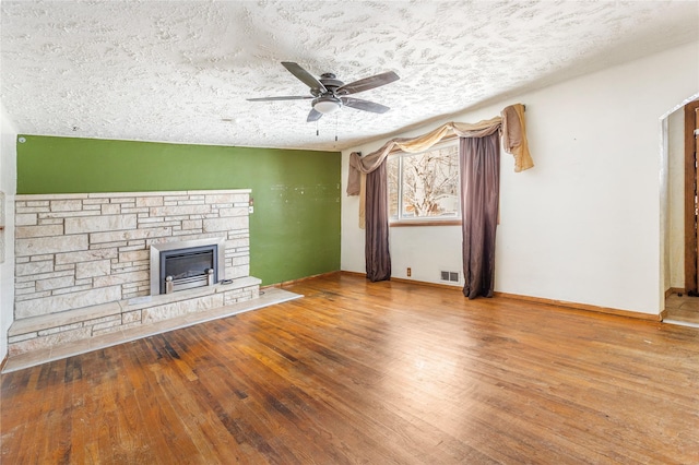 unfurnished living room featuring wood-type flooring, a textured ceiling, visible vents, and a ceiling fan