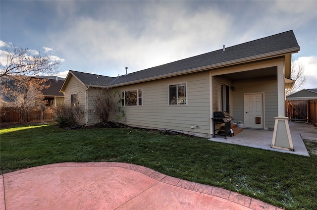 rear view of house with a patio and a lawn