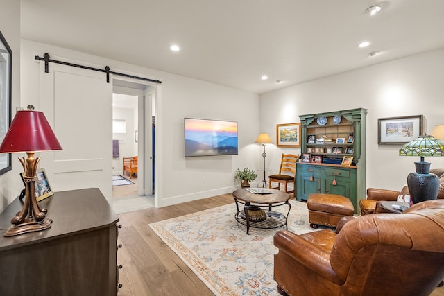 living room featuring light wood-type flooring and a barn door