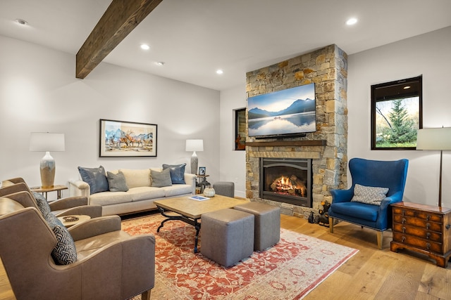 living room with a fireplace, light hardwood / wood-style floors, and beam ceiling