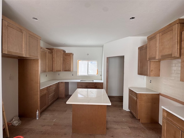 kitchen with hardwood / wood-style flooring, a kitchen island, and backsplash