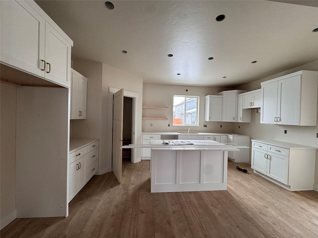 kitchen with a center island, light hardwood / wood-style floors, and white cabinets