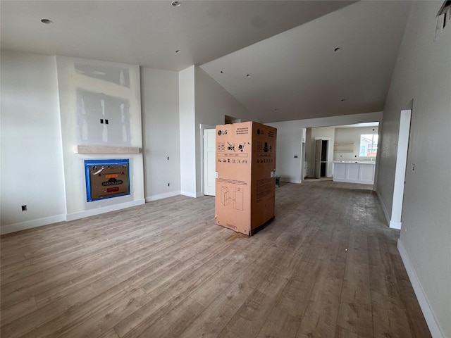 unfurnished living room featuring light wood-type flooring and high vaulted ceiling