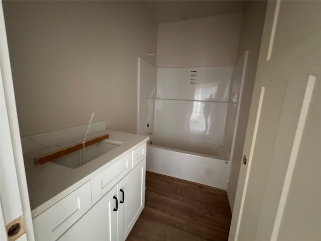 bathroom featuring hardwood / wood-style flooring, vanity, and bathing tub / shower combination