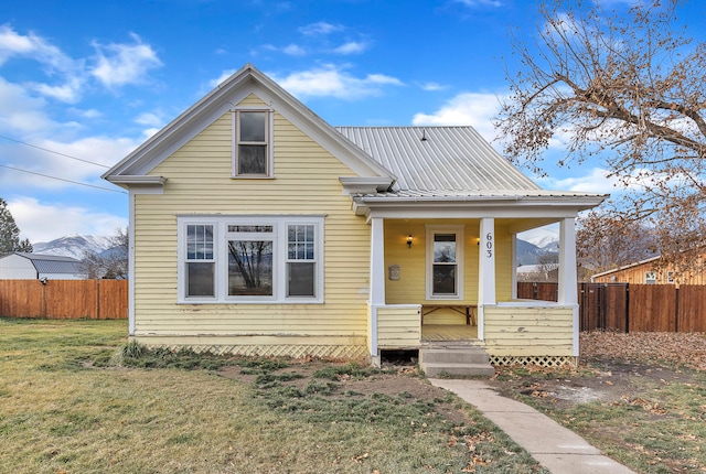 view of front facade featuring a mountain view, a porch, and a front yard