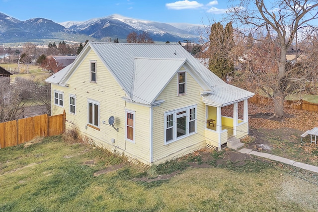 back of house with a mountain view and a yard