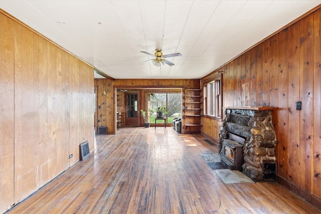 1312 2nd Ave E, Kalispell, MT 59901 - unfurnished living room featuring wood walls, wood-type flooring, and a ceiling fan