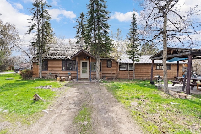 1312 2nd Ave E, Kalispell, MT 59901 - view of front of house with a front yard, dirt driveway, a chimney, and a gazebo