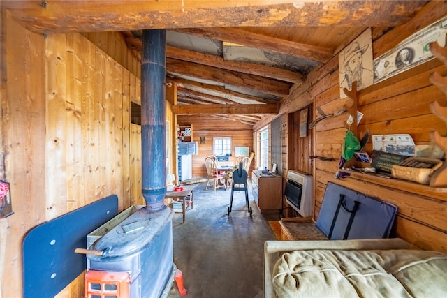 miscellaneous room with wood walls, heating unit, a wood stove, and vaulted ceiling