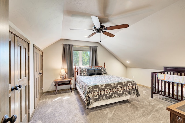 bedroom featuring carpet, ceiling fan, vaulted ceiling, and two closets