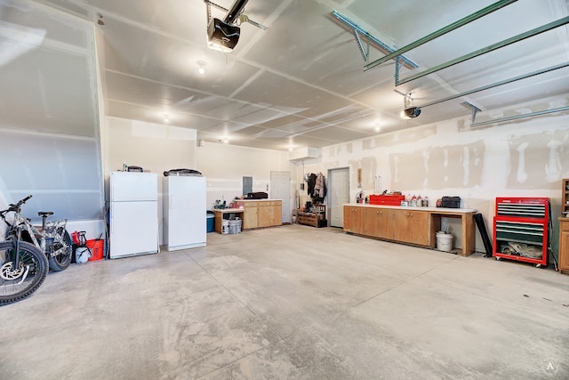 garage featuring a garage door opener, a workshop area, and white fridge