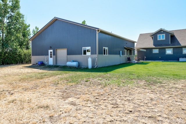 back of property with a lawn and an outdoor structure