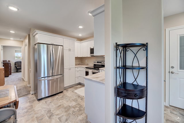 kitchen featuring white cabinetry, light stone countertops, and stainless steel appliances