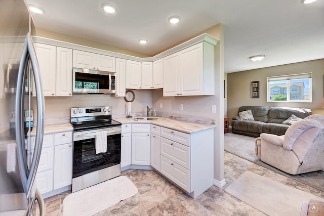 kitchen with white cabinets, appliances with stainless steel finishes, and sink