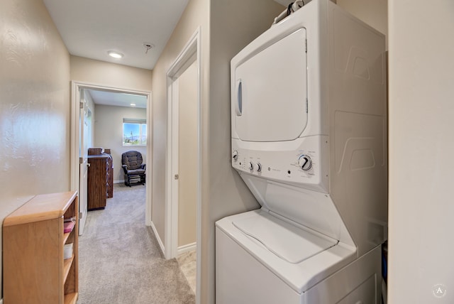 clothes washing area with stacked washer and dryer and light colored carpet