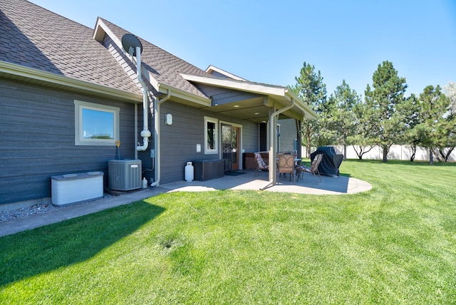 back of property featuring central air condition unit, a yard, and a patio area