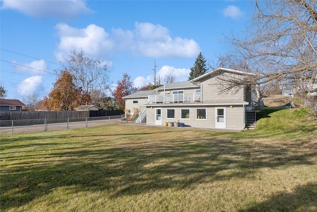 back of property with a yard and a wooden deck