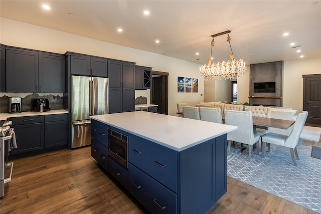 3868 Gelande St Unit 4, Whitefish, MT 59937 - kitchen featuring light countertops, stainless steel appliances, dark wood finished floors, an inviting chandelier, and a center island