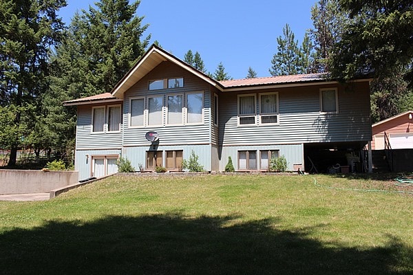 back of house featuring a lawn