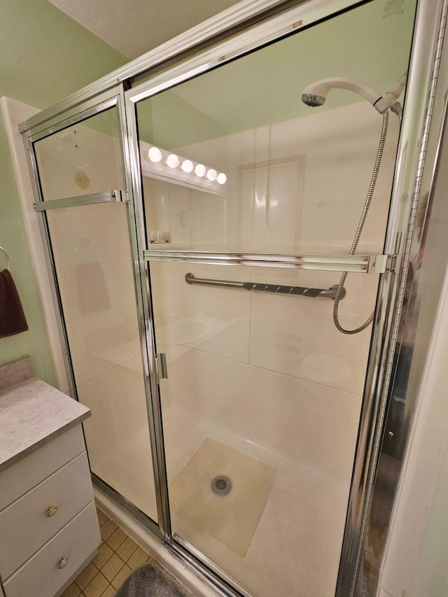 bathroom featuring tile patterned flooring, vanity, and a shower with shower door