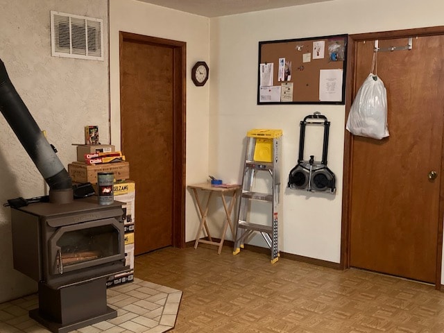 interior space with a wood stove and light parquet floors