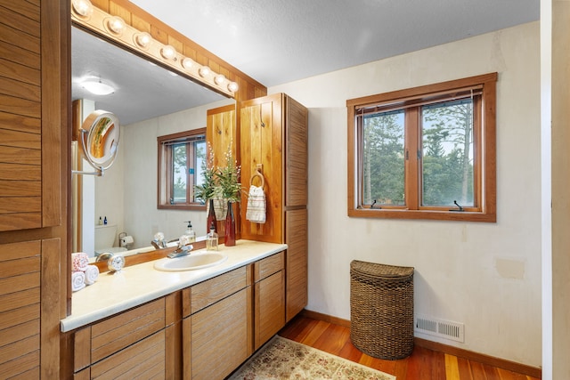 16485 Folsom Rd, Florence, MT 59833 - bathroom featuring baseboards, wood finished floors, toilet, and vanity