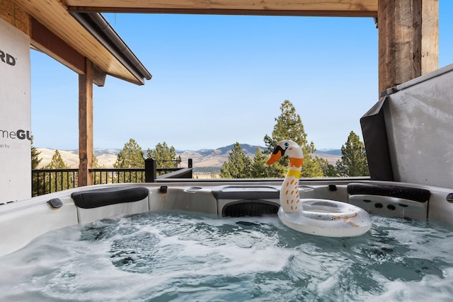 16485 Folsom Rd, Florence, MT 59833 - view of patio / terrace featuring a hot tub, a mountain view, and a balcony