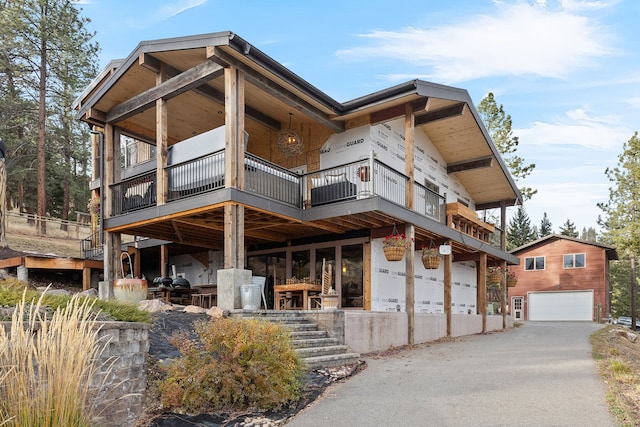 16485 Folsom Rd, Florence, MT 59833 - view of front of house with stairway, asphalt driveway, an outdoor structure, and a garage