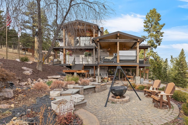 16485 Folsom Rd, Florence, MT 59833 - back of property with an outdoor fire pit, a patio area, stairs, and a deck
