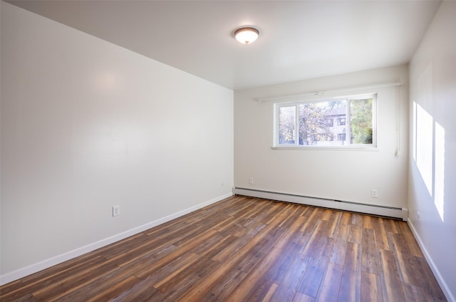 unfurnished room featuring dark wood-type flooring and baseboard heating