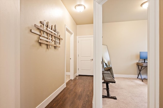 hallway featuring dark carpet