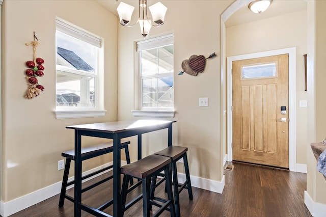 dining area featuring a notable chandelier and dark wood-type flooring