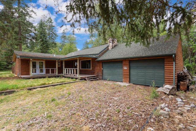 cabin featuring a garage, french doors, and a porch