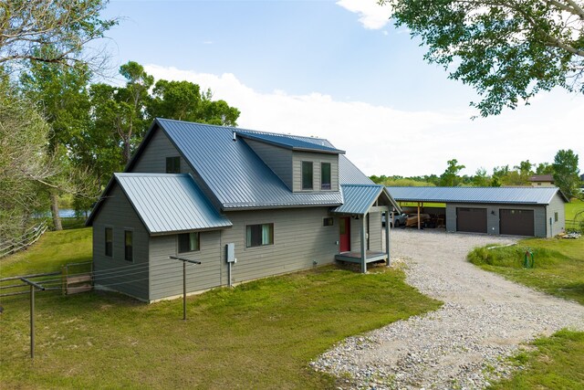 rear view of property featuring a garage, a yard, and an outdoor structure