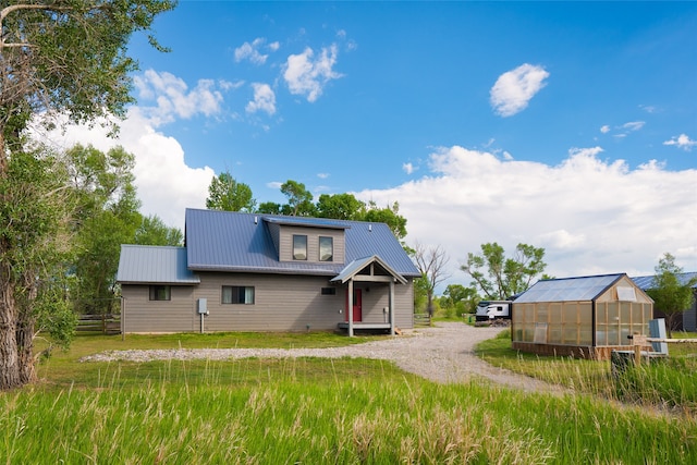 rear view of house featuring an outdoor structure