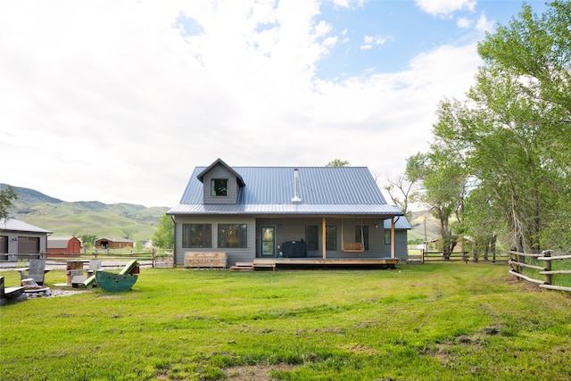 rear view of property with a lawn and a mountain view