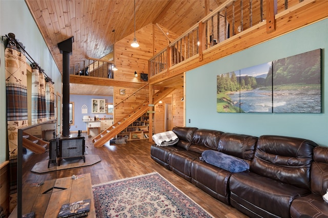 living room featuring wood walls, high vaulted ceiling, hardwood / wood-style floors, wood ceiling, and a wood stove