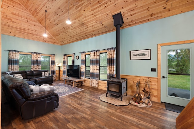 living room with wooden ceiling, high vaulted ceiling, wood-type flooring, a wood stove, and wooden walls