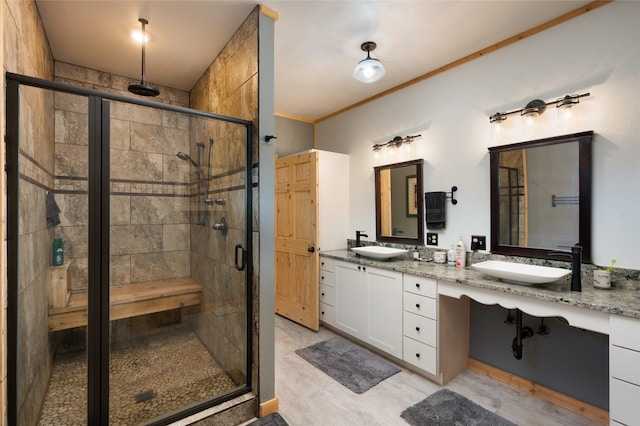 bathroom with vanity, crown molding, and a shower with shower door