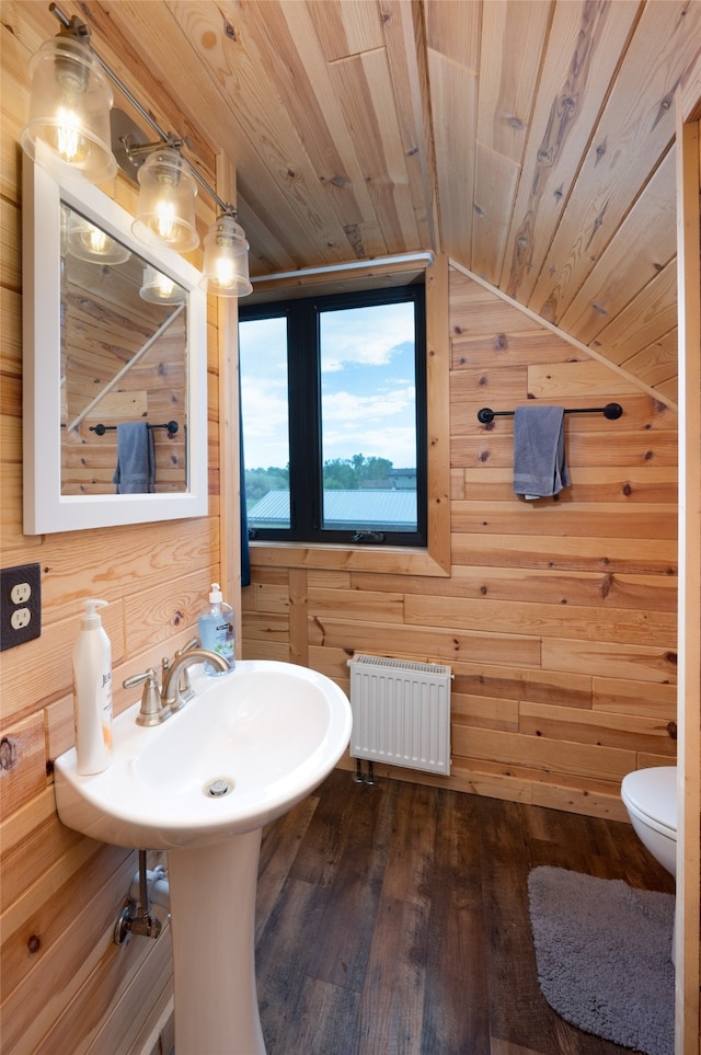 bathroom with radiator, wood-type flooring, wood walls, vaulted ceiling, and wooden ceiling