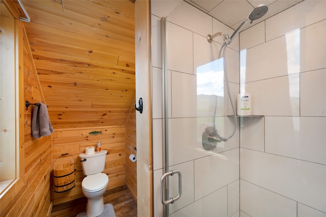 bathroom with wood walls, hardwood / wood-style flooring, toilet, and an enclosed shower