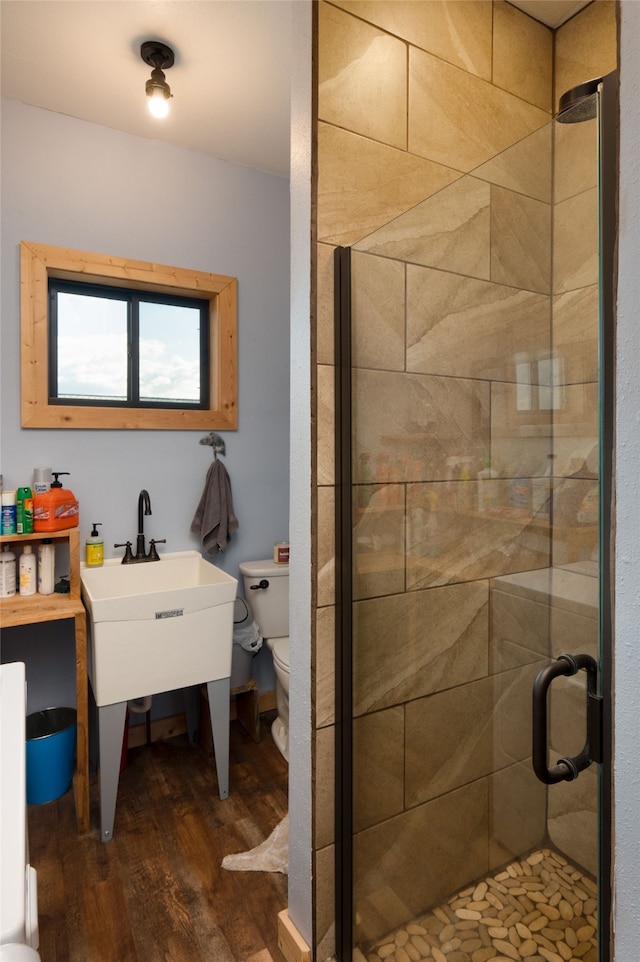 bathroom featuring wood-type flooring, toilet, and an enclosed shower