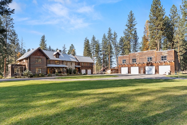 log cabin featuring a front lawn and a garage