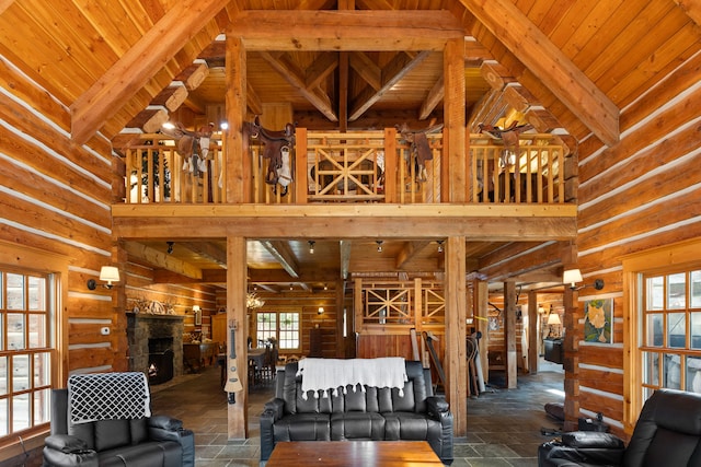 living room with beamed ceiling, high vaulted ceiling, wooden ceiling, and a stone fireplace